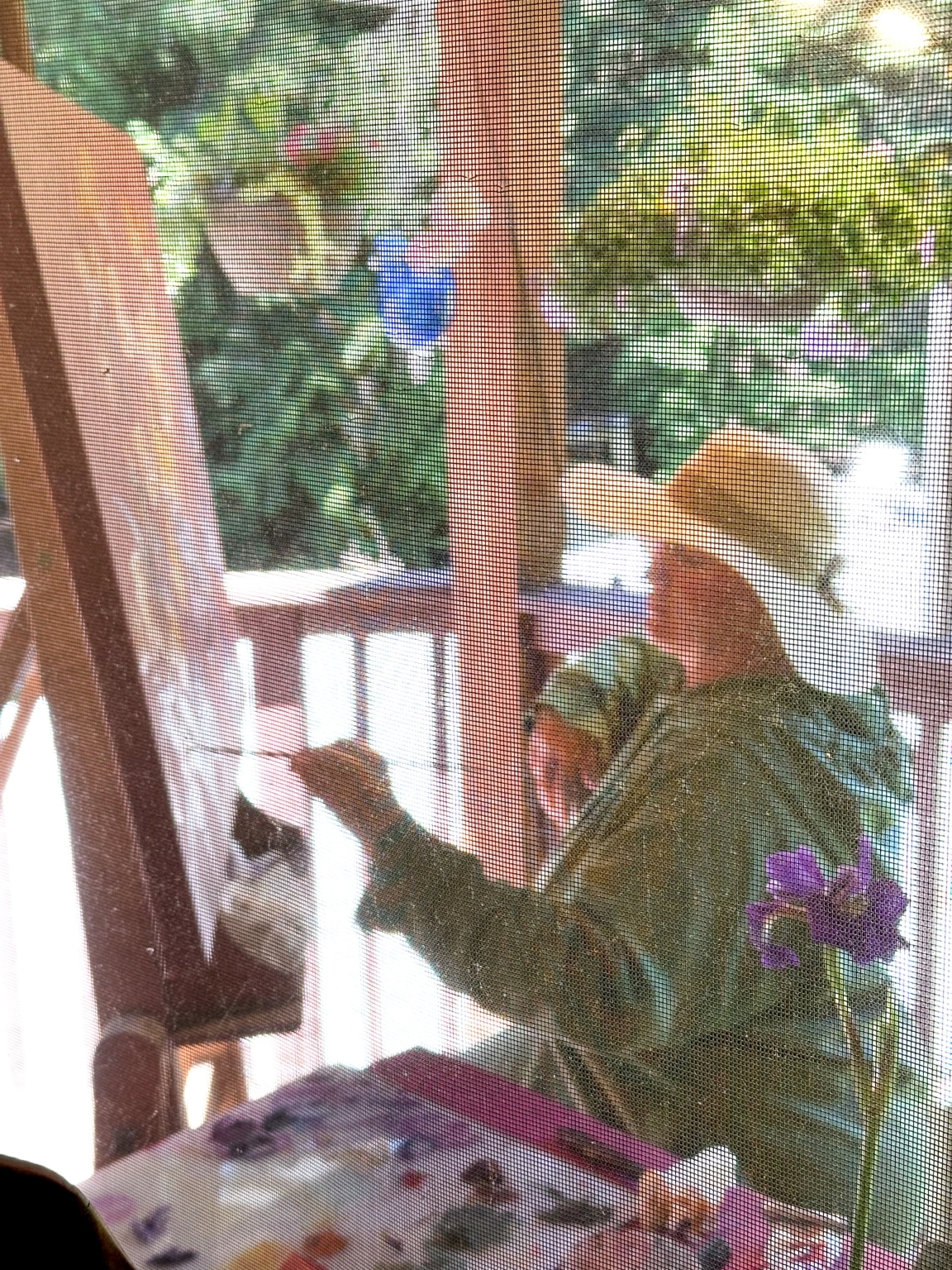 Maia Leisz painting at her easel on the porch