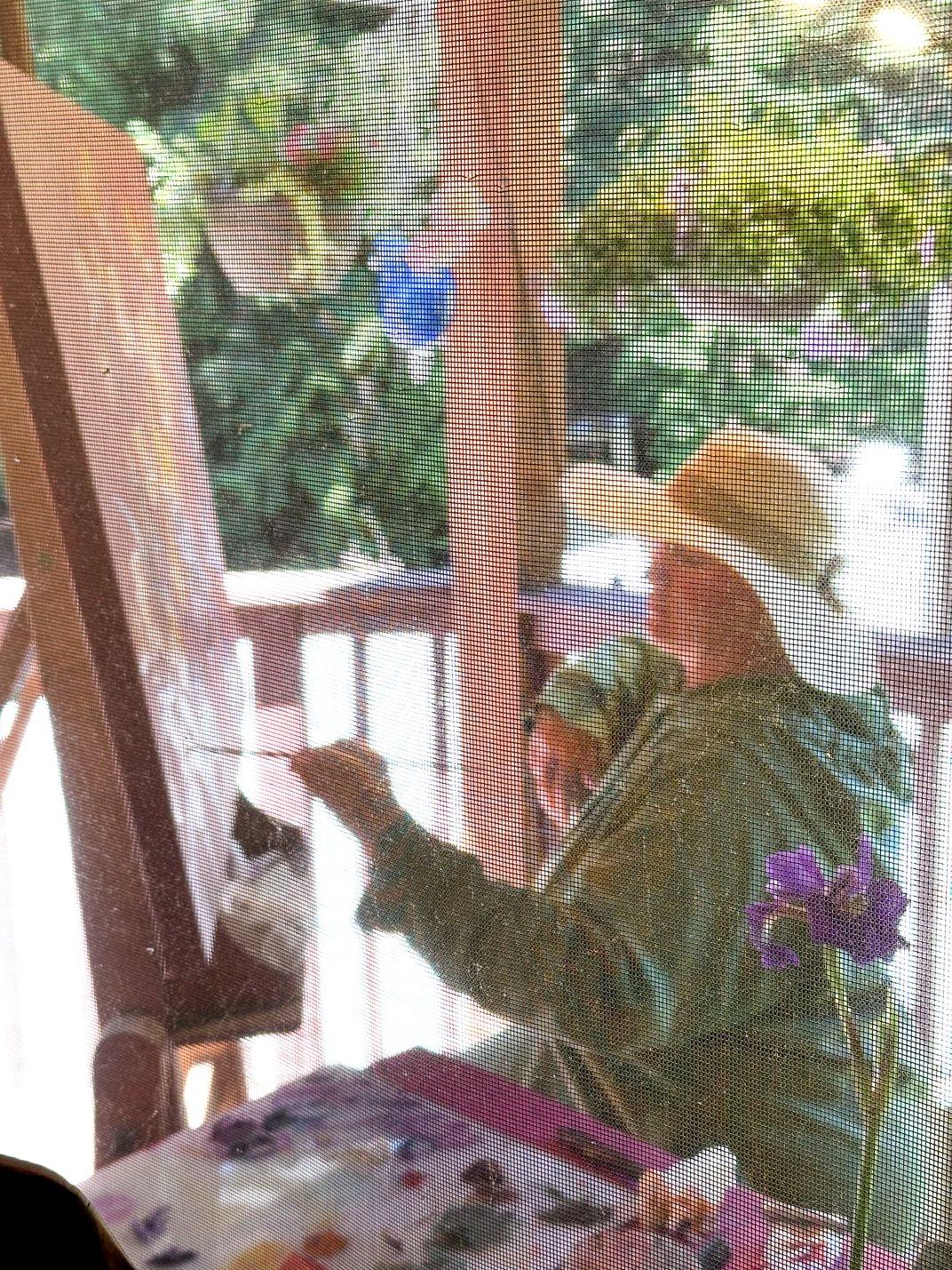 Maia Leisz painting at her easel on the porch